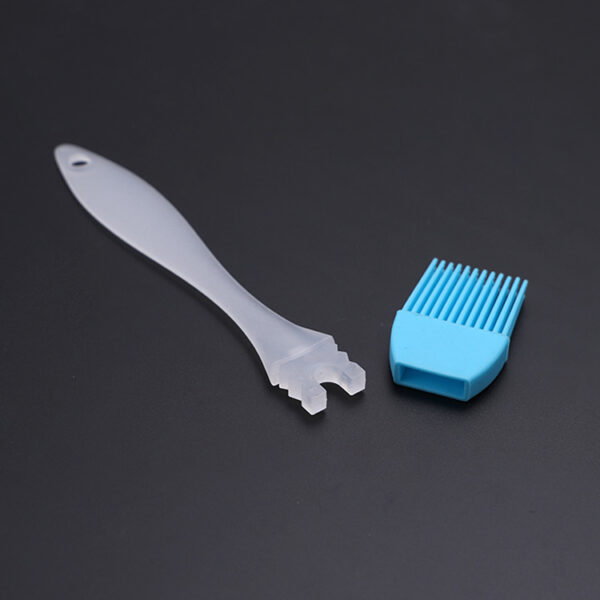 Silicone baking brush spreading oil over a baking surface